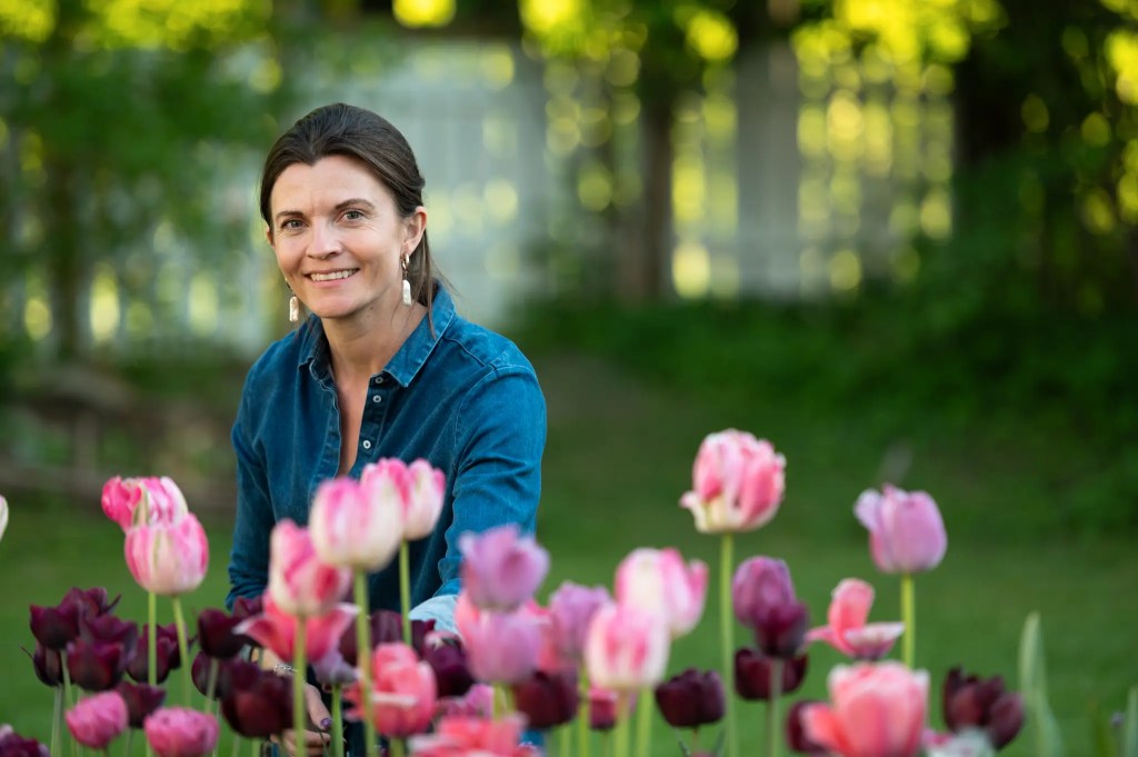 Madeleine Strand foran blomstrende tulipaner. Planting av tulipanløk gjør hun i oktober